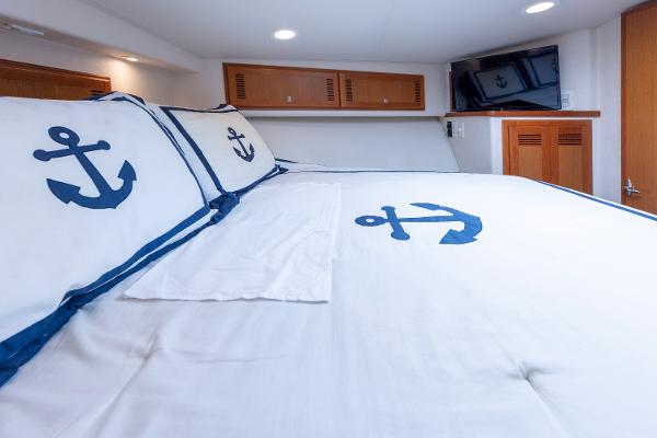 Slide: The Image of 2005 Cabo 40 Express cabin with anchor-themed bedding and modern amenities. - 30