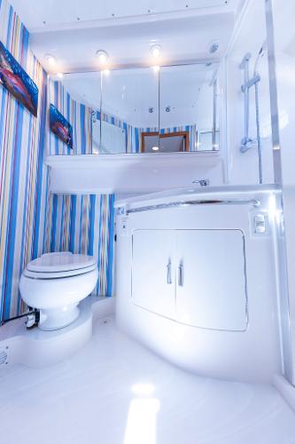 Slide: The Image of 2005 Cabo 40 Express yacht bathroom with striped walls, modern fixtures, and white cabinetry. - 31