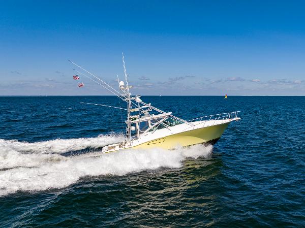 Slide: The Image of 2005 Cabo 40 Express yacht cruising on open sea under clear blue sky. - 39