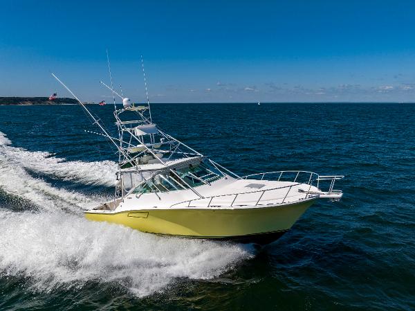Slide: The Image of 2005 Cabo 40 Express yacht cruising on open water under clear blue skies. - 4
