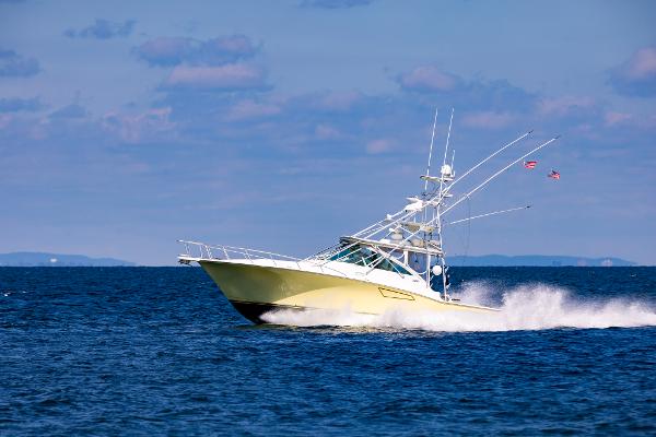 Slide: The Image of 2005 Cabo 40 Express yacht cruising on open water under a clear sky. - 40