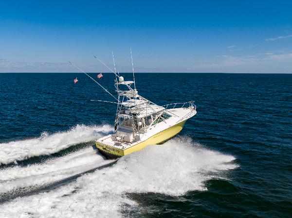 Slide: The Image of 2005 Cabo 40 Express yacht cruising on open sea under clear blue sky. - 42