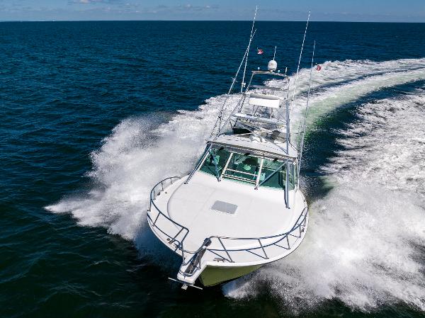 Slide: The Image of 2005 Cabo 40 Express yacht cruising on open water, creating a dynamic wake. - 47