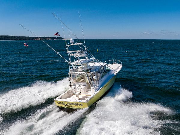 Slide: The Image of 2005 Cabo 40 Express boat cruising on open sea with clear blue skies. - 5