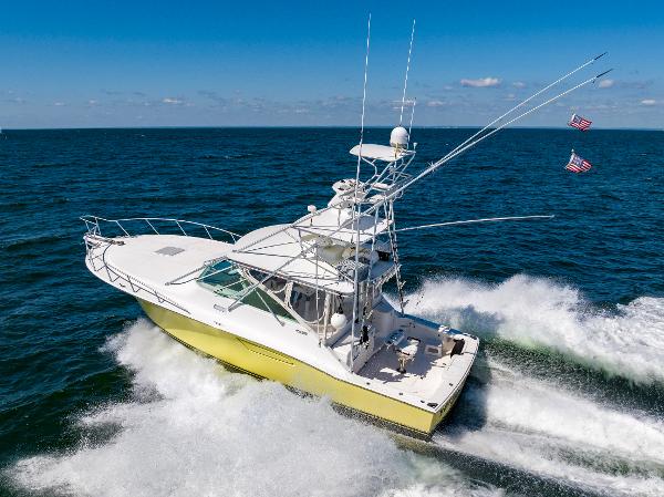 Slide: The Image of 2005 Cabo 40 Express yacht cruising on open sea with flags flying. - 7