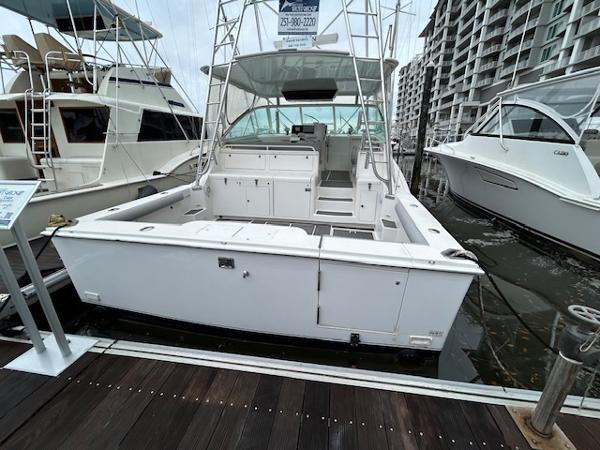 Slide: The Image of 1998 Cabo 45 Express boat docked at marina, rear view. - 1