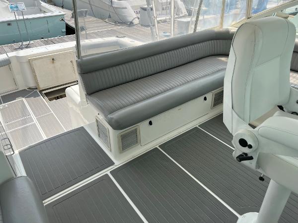Slide: The Image of 1998 Cabo 45 Express boat interior with gray seating and white captain's chair. - 11