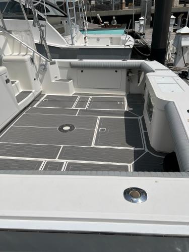 Slide: The Image of 1998 Cabo 45 Express boat deck with cushioned seating and non-slip flooring. - 13