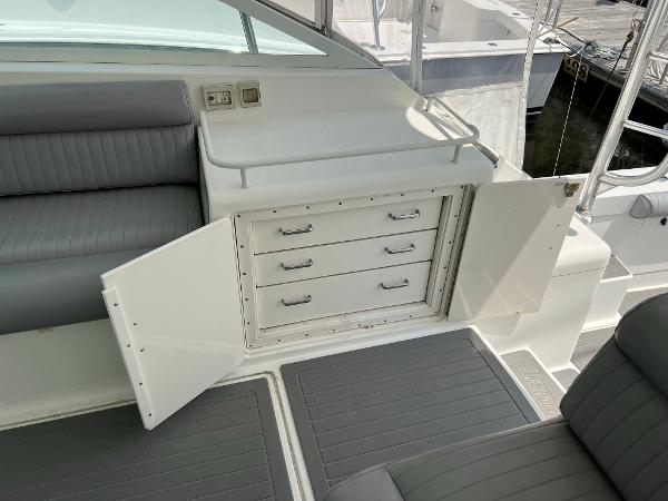 Slide: The Image of 1998 Cabo 45 Express boat interior with open storage drawers and seating. - 14