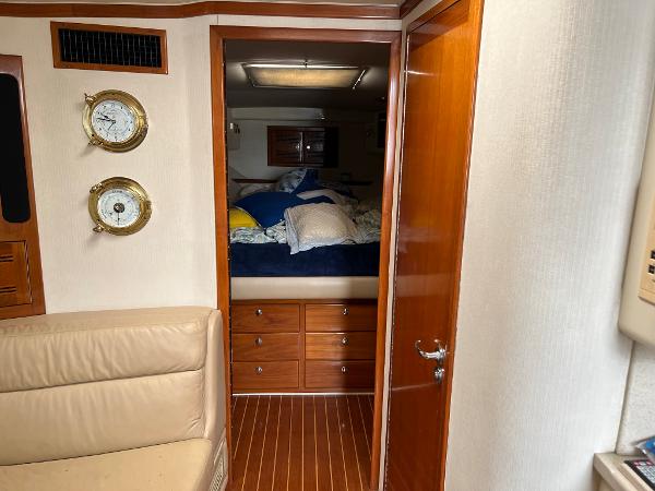 Slide: The Image of 1998 Cabo 45 Express cabin interior with bed, wooden cabinets, and nautical decor. - 22