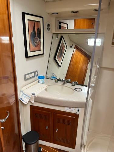 Slide: The Image of 1998 Cabo 45 Express bathroom with sink, mirror, and wooden cabinets. - 25