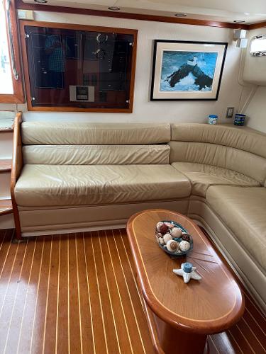 Slide: The Image of Interior of a 1998 Cabo 45 Express yacht with beige leather seating and wooden flooring. - 29