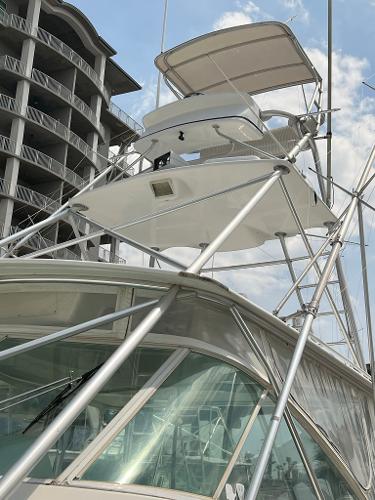Slide: The Image of 1998 Cabo 45 Express boat docked near modern buildings. - 3
