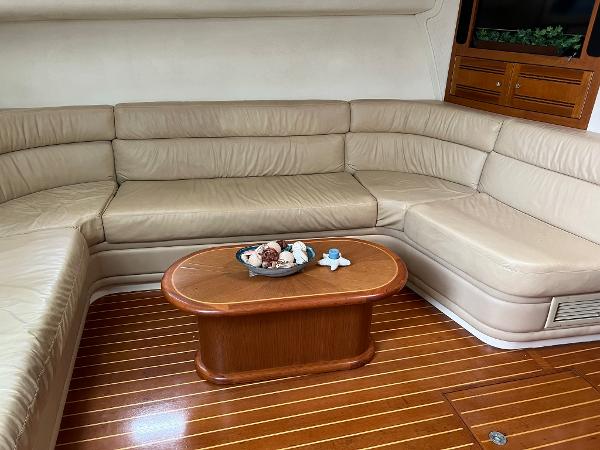 Slide: The Image of Luxurious 1998 Cabo 45 Express yacht interior with beige leather seating and wooden table. - 30