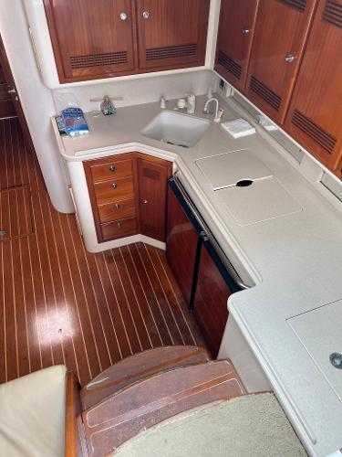 Slide: The Image of 1998 Cabo 45 Express yacht interior kitchen with wooden cabinets and flooring. - 31