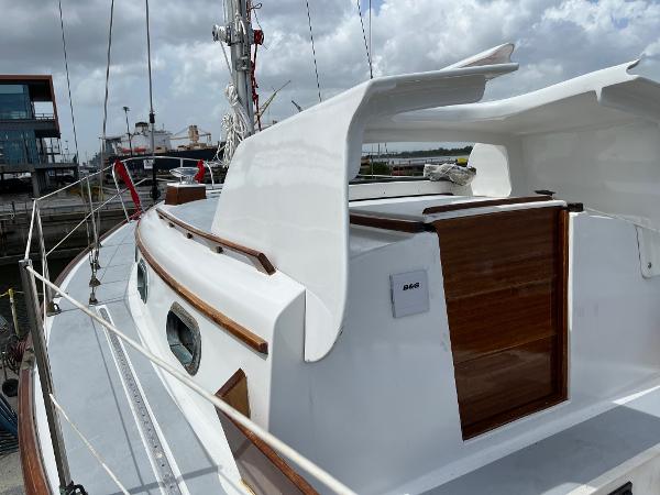 Slide: The Image of 1985 Cape Dory 270 sailboat with wooden accents docked at a marina. - 16
