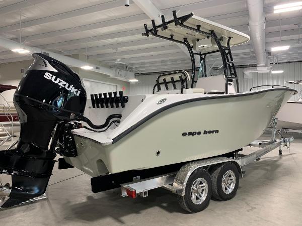 Slide: The Image of 2024 Cape Horn 22 OS boat with Suzuki outboard motor on trailer in indoor showroom. - 2