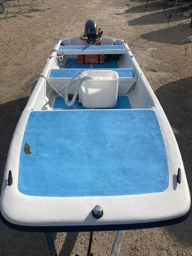 Slide: The Image of 1997 Carolina Skiff 16 DLX boat with blue deck and outboard motor. - 4
