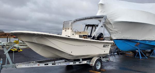 Slide: The Image of 2023 Carolina Skiff 17 LS boat on a trailer in a marina. - 2