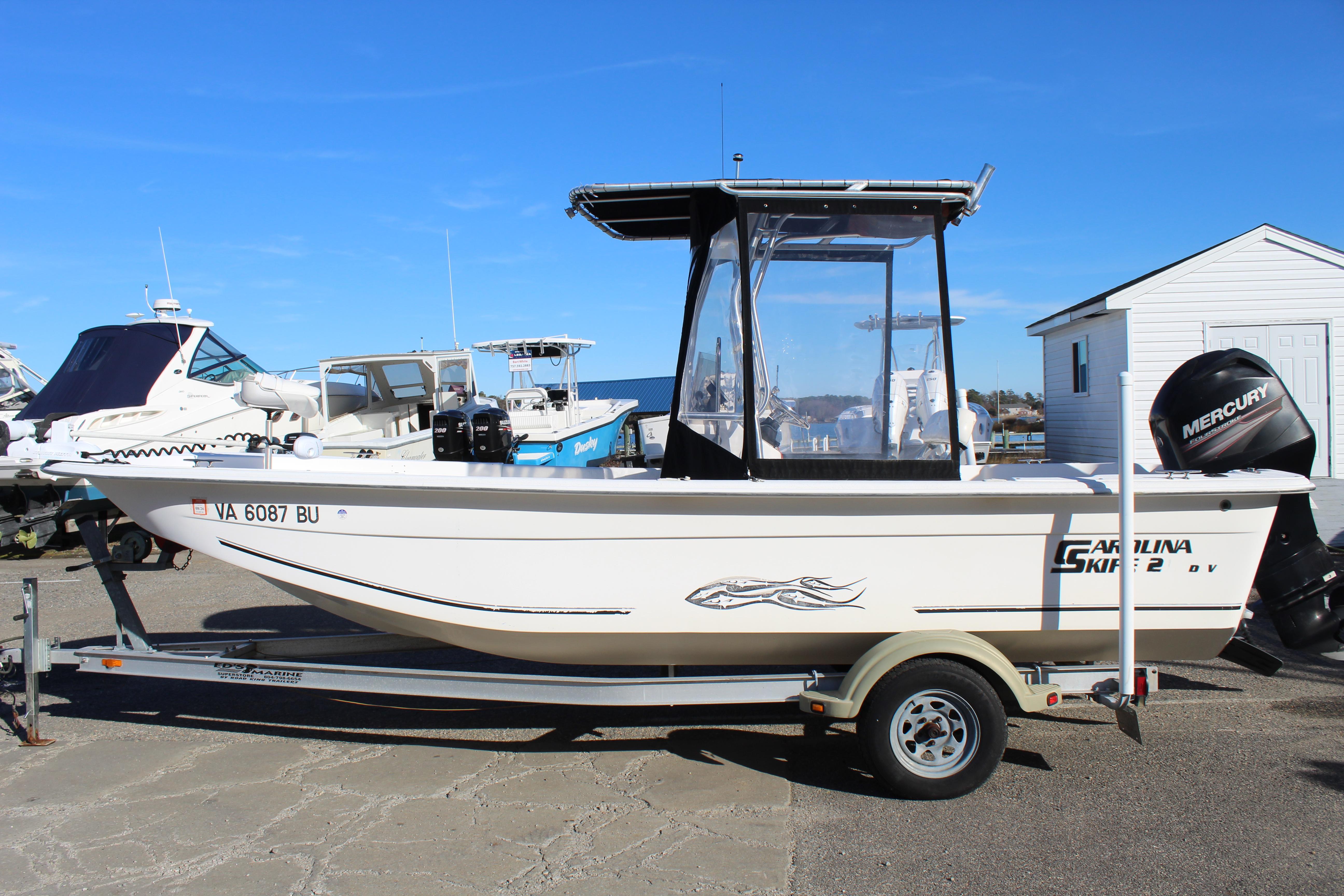 Slide: The Image of 2011 Carolina Skiff 218 DLV boat on trailer with Mercury outboard motor. - 1