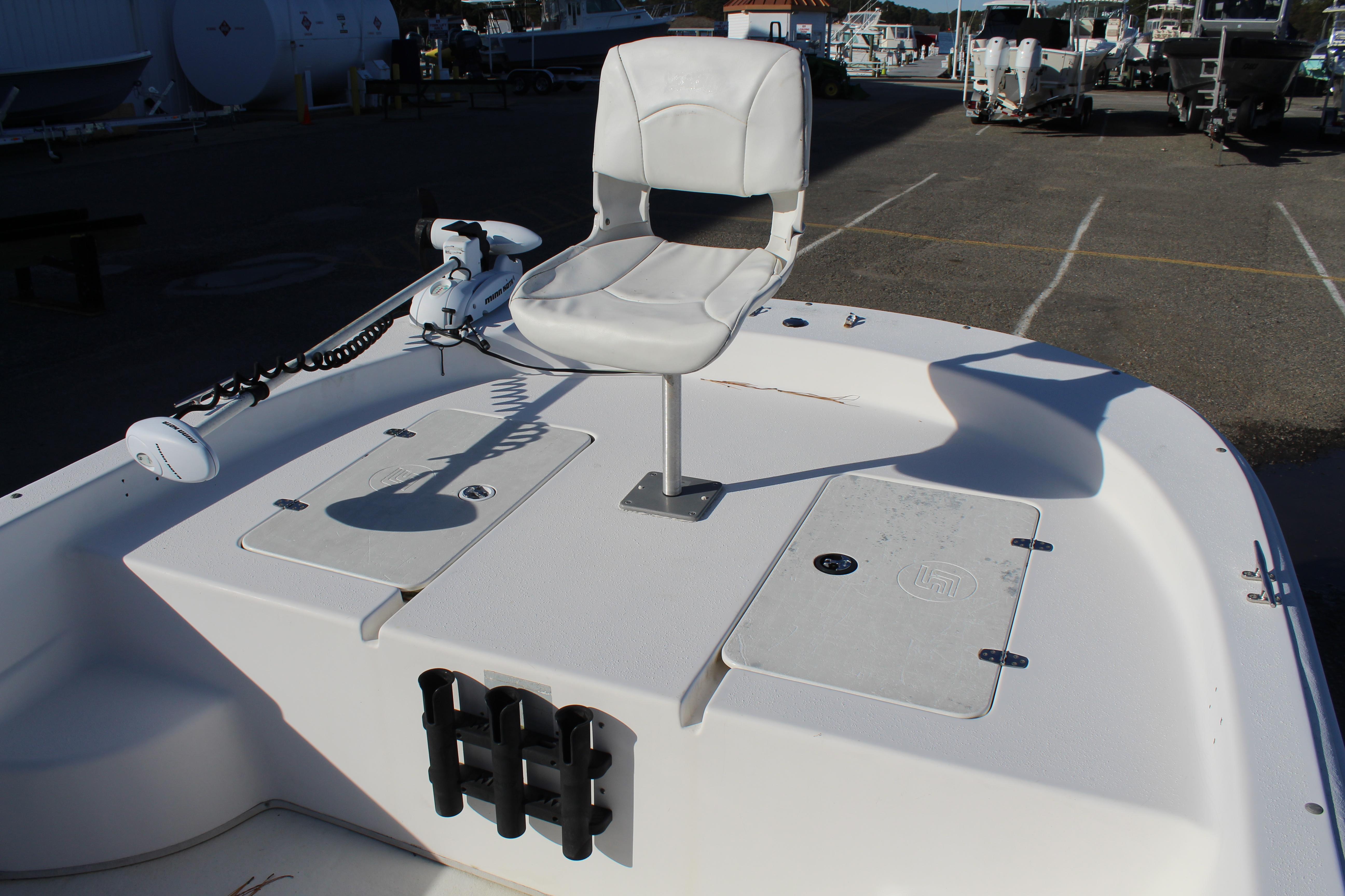 Slide: The Image of 2011 Carolina Skiff 218 DLV boat with white seating and storage compartments. - 18