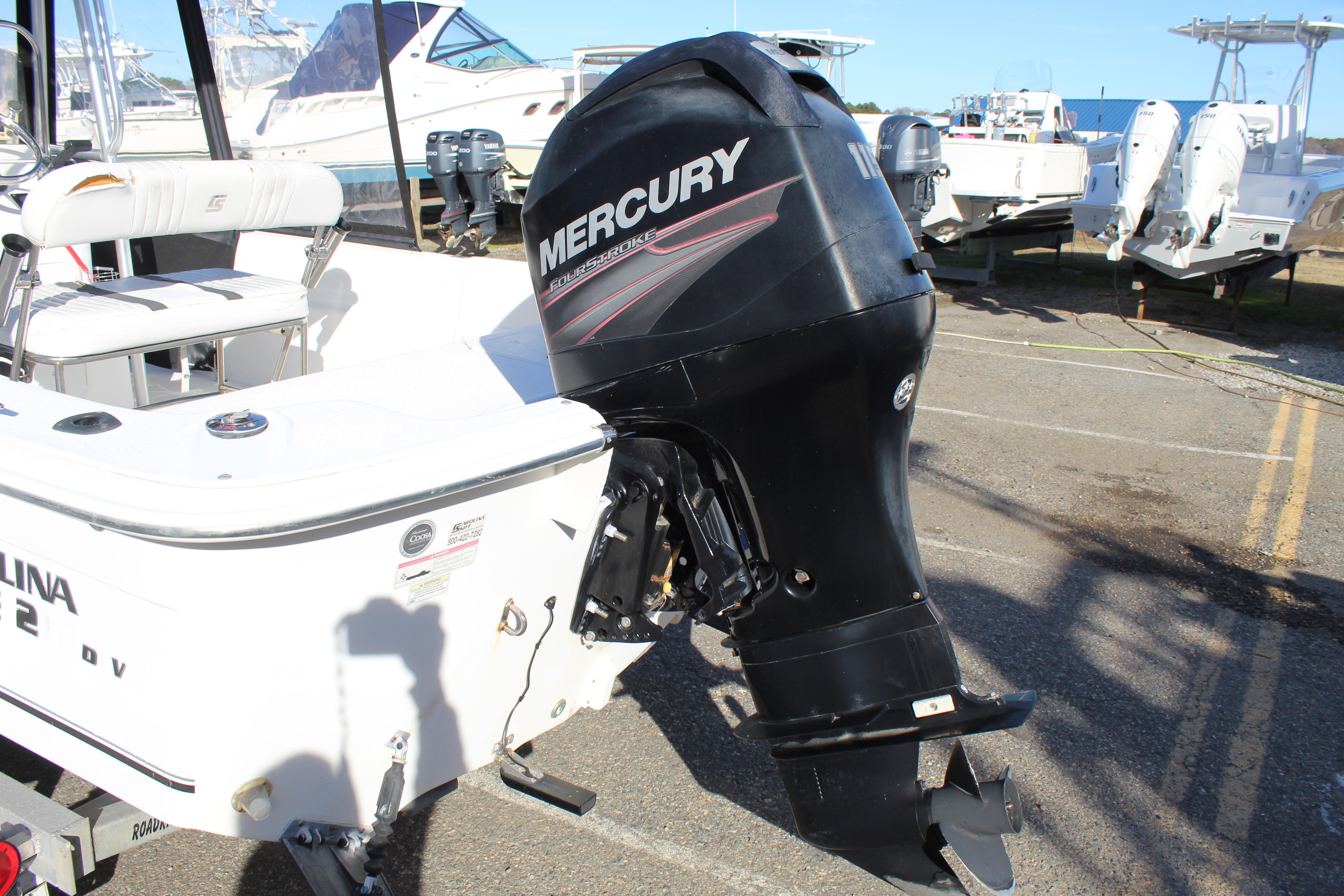 Slide: The Image of 2011 Carolina Skiff 218 DLV with Mercury outboard motor in a marina setting. - 8