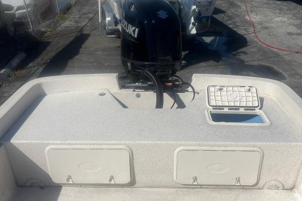 Slide: The Image of 2024 Carolina Skiff e24 DLX boat with Suzuki outboard motor, rear storage compartments. - 3