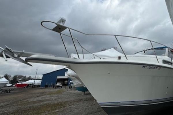 Slide: The Image of 1993 Carver 280 Express boat on land under cloudy sky. - 1