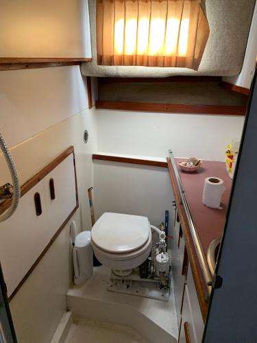 Slide: The Image of 1986 Carver 28 Riviera boat bathroom with toilet, sink, and window. - 13
