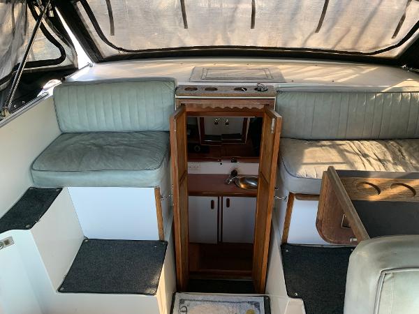 Slide: The Image of 1986 Carver 28 Riviera interior with seating and cabin entrance. - 6