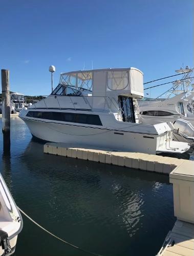 Slide: The Image of 1988 Carver 32 Mariner yacht docked at a marina on a sunny day. - 1