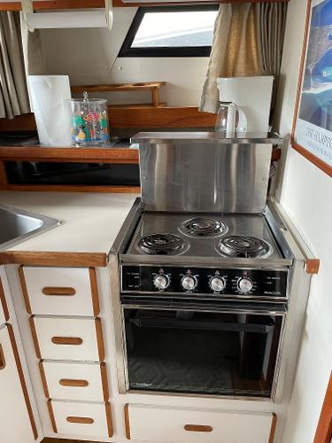 Slide: The Image of 1988 Carver 32 Mariner kitchen with stove and storage drawers. - 11