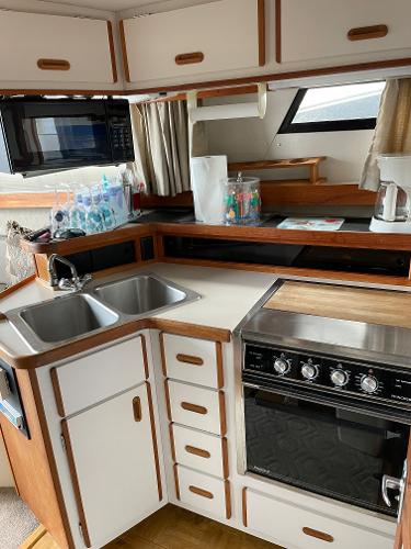 Slide: The Image of 1988 Carver 32 Mariner kitchen with dual sinks, stove, and microwave. - 12
