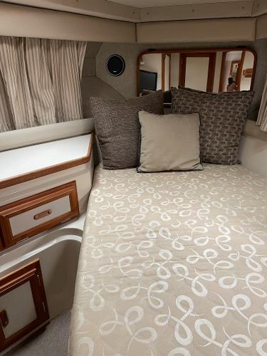 Slide: The Image of 1988 Carver 32 Mariner cabin interior with bed, pillows, and storage drawers. - 14