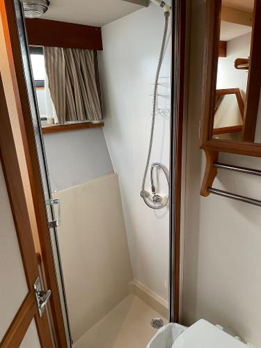 Slide: The Image of Bathroom interior of a 1988 Carver 32 Mariner boat with shower and wooden accents. - 15