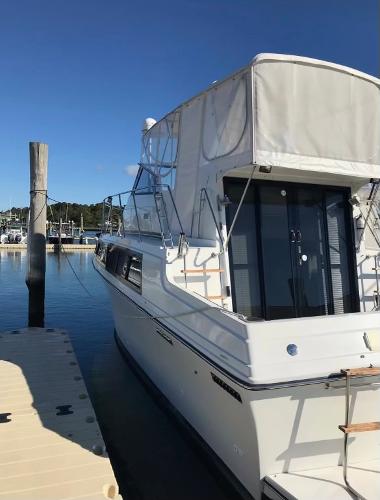 Slide: The Image of 1988 Carver 32 Mariner docked at a marina on a sunny day. - 2