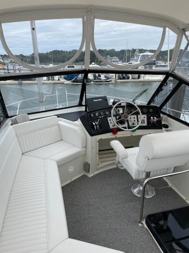 Slide: The Image of 1988 Carver 32 Mariner boat interior with white seating and helm station. - 5