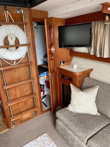 Slide: The Image of Interior of 1988 Carver 32 Mariner with TV, sofa, and life preserver. - 7
