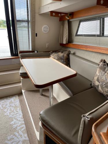 Slide: The Image of Interior of 1988 Carver 32 Mariner with dining area and cushioned seating. - 9