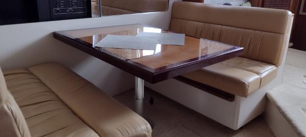 Slide: The Image of Interior dining area of 2002 Carver 356 Motor Yacht with beige seating and wooden table. - 26