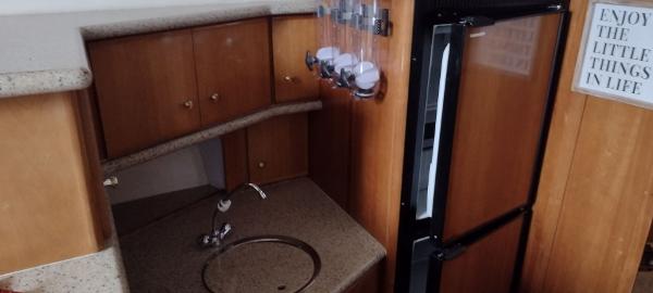 Slide: The Image of 2002 Carver 356 Motor Yacht kitchen with wood cabinets, countertop, and refrigerator. - 28