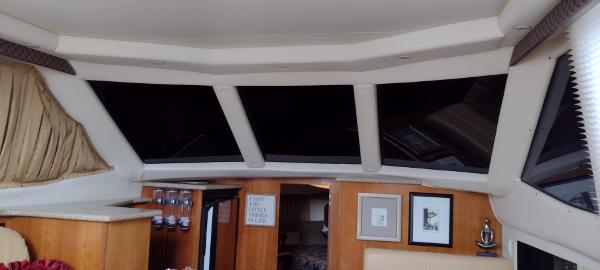 Slide: The Image of Interior of 2002 Carver 356 Motor Yacht with large windows and wood accents. - 33