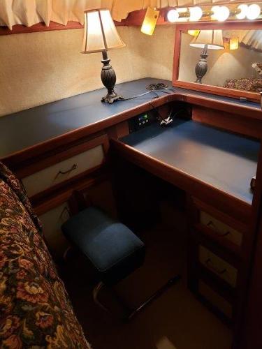 Slide: The Image of 1986 Carver 36 Aft Cabin interior with desk, lamp, and mirror. Cozy and vintage design. - 3