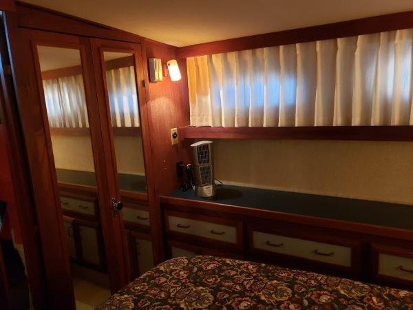 Slide: The Image of 1986 Carver 36 Aft Cabin interior with wood paneling and floral bedspread. - 5
