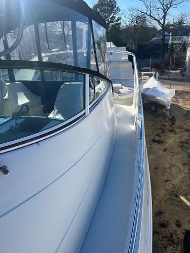 Slide: The Image of 2006 Carver 36 Mariner yacht docked, side view with clear canopy and seating area. - 43