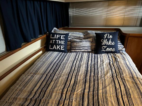Slide: The Image of 1992 Carver 38 Aft Cabin bedroom with striped bedding and themed pillows. - 11