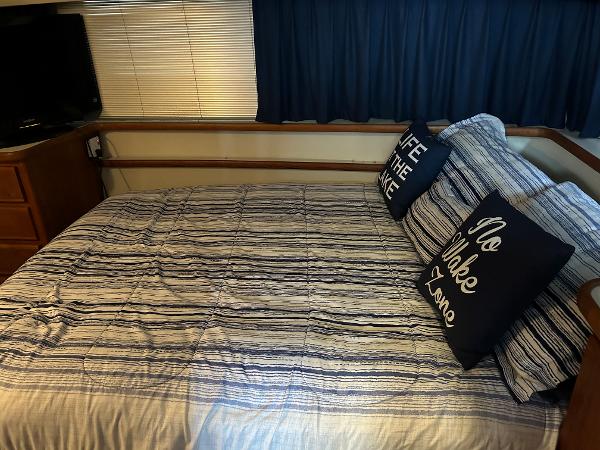 Slide: The Image of 1992 Carver 38 Aft Cabin bedroom with striped bedding and nautical-themed pillows. - 17