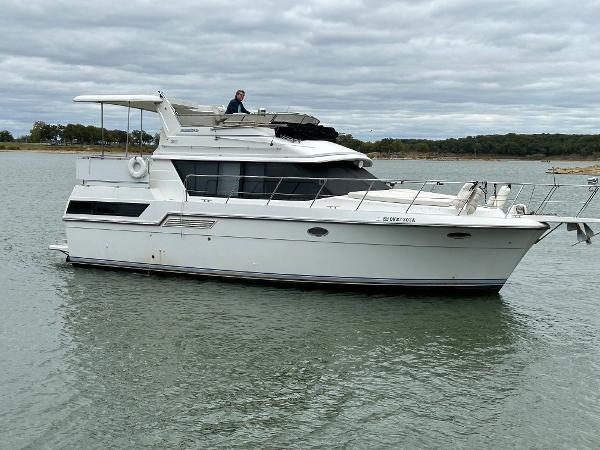 Slide: The Image of 1992 Carver 38 Aft Cabin yacht on calm water under cloudy skies. - 2
