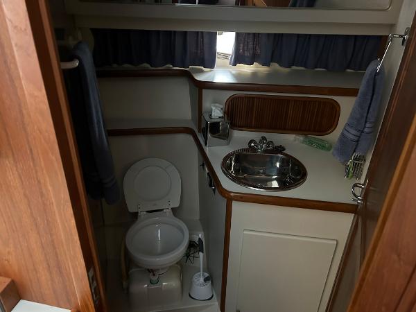 Slide: The Image of 1992 Carver 38 Aft Cabin bathroom with sink, toilet, and wooden accents. - 21