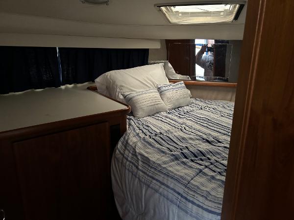 Slide: The Image of 1992 Carver 38 Aft Cabin bedroom with striped bedding and wooden cabinetry. - 22